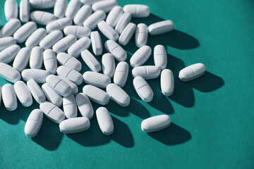 Medical Pills on vibrant cyan or aqua background. 80s and 90s retro style, hard light and contrast...