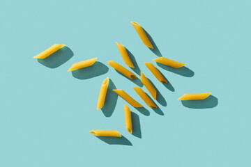 Penne pasta on aqua blue or cyan background. Retro style food photo background