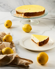 Mascarpone cheesecake with lemon curd and shortbread base. White marble background. High key food photo