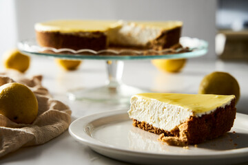 Mascarpone cheesecake with lemon curd and shortbread base. White marble background. High key food photo