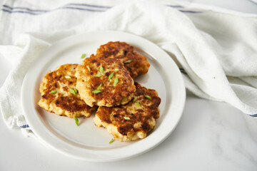  Golden Brown Chopped Chicken Cutlets or Patties with mozzarella cheese on white vintage plate. Minimalistic food photo on white marble background