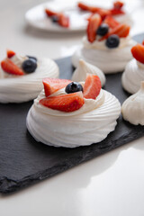 Pavlova dessert with fresh berries. Meringue with strawberries and blueberries. 