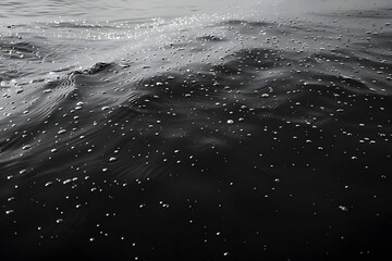 a black and white photo of the surface of a large body of water with small dots of water on it. - Powered by Adobe