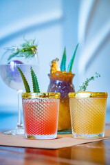 Four colorful summer cocktails with dill and agave garnish