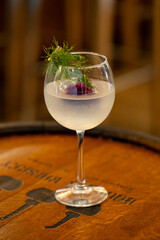 Clear cocktail in a stemmed globe infused with rose and garnished with dill