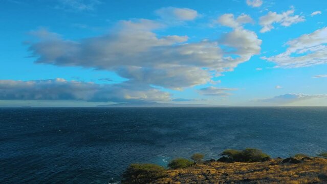 Panning shot of the Pacific ocean as seen from the Papawai lookout point. Aerial view of dark blue ocean and sky with clouds. Hawaiian seascape.
