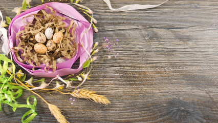 Eggs in the nest decorated with ribbons and flowers. Easter celebration concept.