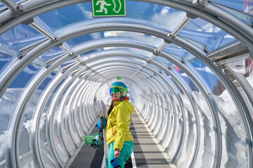 Snowboarder Walking Through a Covered Conveyor