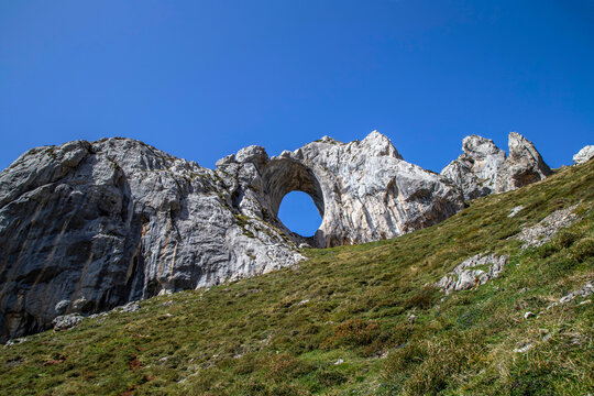 Ojo de Buey is an imposing natural rock arch located on one of the best-known peaks in the region: Pe&ntilde;a Mea, located at 1,557 meters high. Aller, Asturias, Spain.