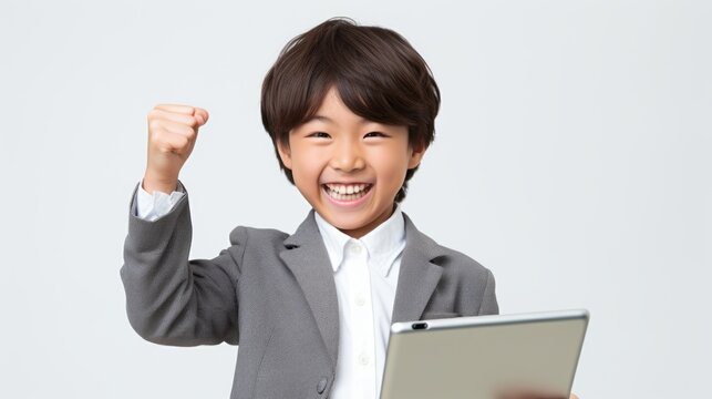 Portrait of a asian boy showing biceps, kid is smiling and holding tablet, white background.
