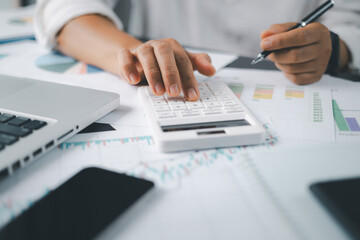 Business financing accounting banking concept. Businesswoman hand doing finances and calculate on desk about cost at home office. Woman working on desk with using calculator, finance accounting.