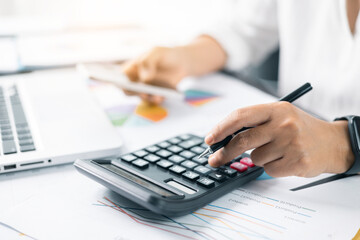 Businesswoman hand doing finances and calculate on desk about cost at home office. Business financing accounting banking concept. Woman working on desk with using calculator, finance accounting.