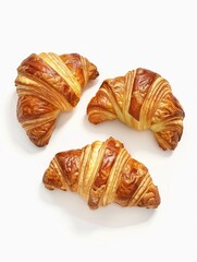 Three croissants are displayed on a white background. The croissants are golden brown and appear to be freshly baked. The croissants are arranged in a triangular shape, with one on the left