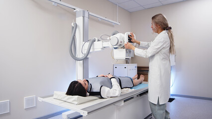 A specialist radiologist doctor installs an x-ray scanner for a patient. Medical research, injury and treatment concept.