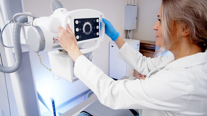 Close-up of a medical worker's hands in an x-ray room preparing x-ray equipment for scanning. The concept of modern medical technologies and equipment.