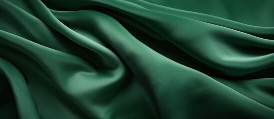 Fototapeta premium Close-up view of a smooth, vibrant green silk fabric with a soft and luxurious texture