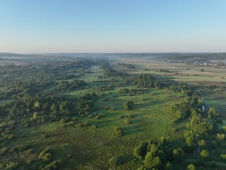 Brzask na wsi z lotu ptaka, ujęcia z drona wsi o brzasku, wschód słońca na wsi, pusząca się o poranku wieś, pola owite mgłą o brzasku, poranek we mgle © klumb