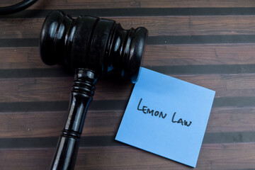 Concept of Lemon Law write on sticky notes with gavel isolated on Wooden Table.