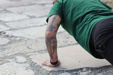 Strength in Ink: Young Man with Tattoos Doing Push-Ups