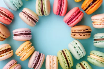 Poster assorted colorful macarons arranged in a circle on a blue background © Klay