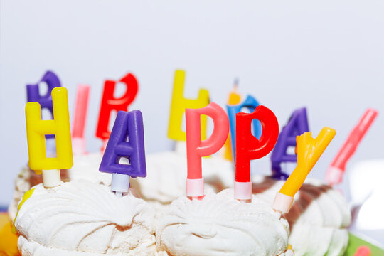 Birthday cake with happy birthday candles on white background