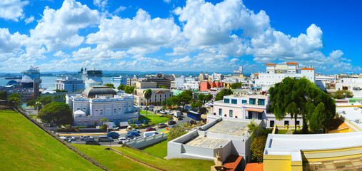Old San Juan historic district skyline, vibrant landmark buildings and houses, and dramatic tropical cloudscape in Puerto Rico - obrazy, fototapety, plakaty