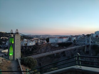 Panoramic view of a city built on the top of rock and its suspension bridge at sunset in Constantine, Algeria
