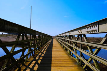 Fototapeta na wymiar Pedestrian bridge leading to sea shore sand beach outdoors scenic landscape photo.