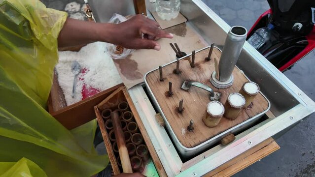 4k video footage of a javanese man cooking of Kue Putu using cylindrical bamboo mold and steamer. Indonesian traditional food or snack from Java, made from grated coconut, brown sugar, palm sugar.