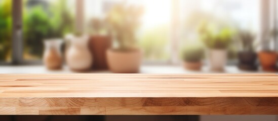 A rectangular hardwood table with a wood stain and varnish finish is positioned in front of a window, with potted plants adding a natural touch to the background - obrazy, fototapety, plakaty