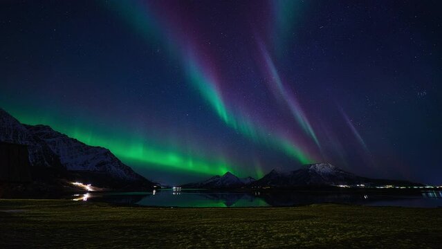 Aurora forming elegant and colorful lines in the sky above a northern Norwegian landscape in March.
