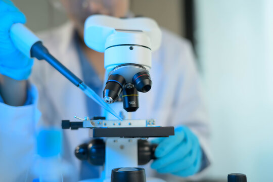 A scientist is using a microscope to examine a sample
