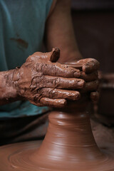 Hands of a craftsman working with clay