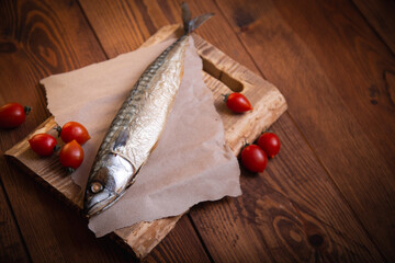 Cooked mackerel with tomatoes on the kitchen table. Rural style.