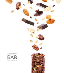 Creative layout made of chocolate protein bar with chocolate, almonds, oatmeal and cacao beans on white background. Flat lay. Food concept.