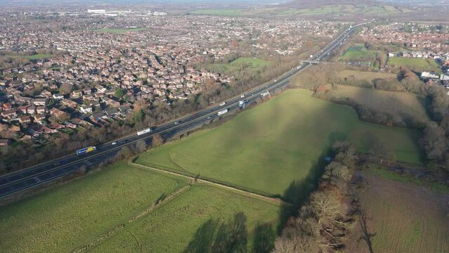 Aerial Advance Through a Highway Surrounded by Houses and Fields