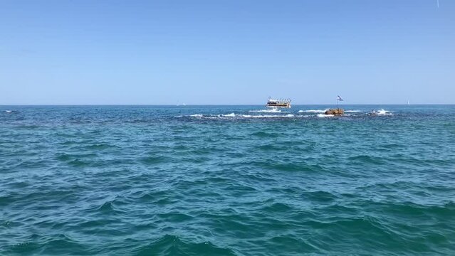 Lighthouse Marina of Old Jaffa. Andromeda stones and the flag of Israel. Mediterranean sea, concept of travel to the holy land, sailing. Slow motion.