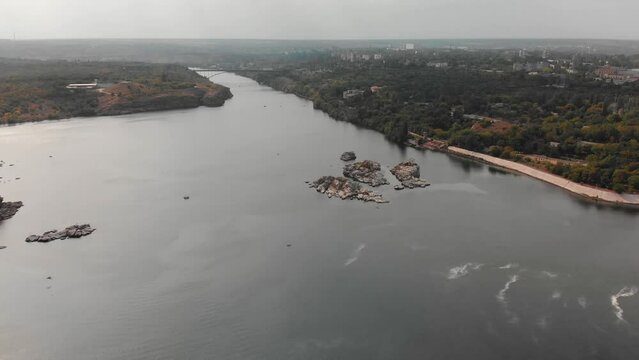 Beautiful view from above of the Khortytsia island in Zaporozhye. Drone view of the Dnieper River and the bridge. Multi-storey buildings, forest. Embankment in Zaporozhye.