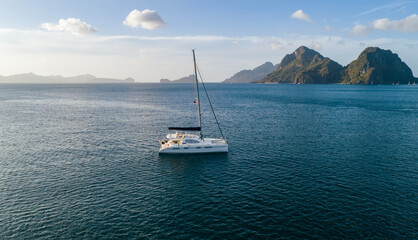 Aerial drone view of sailing yacht anchored in the bay with clear and turquoise water on the...