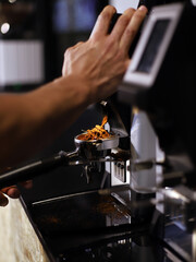 barista echando café molido en el mango de la cafetera para elaborar café