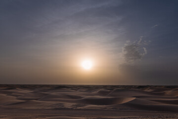 Beautiful dramatic clouds sunset sunrise over the desert sand dune of Abu Dhabi