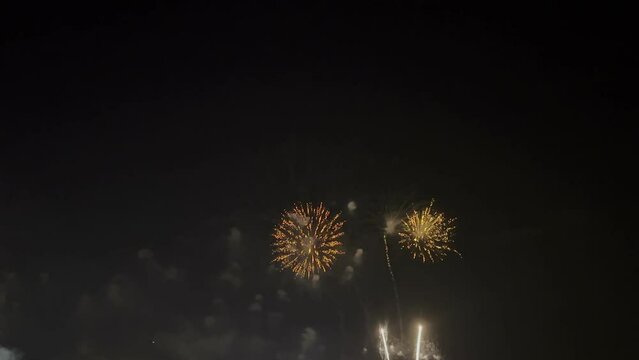 Colorful fireworks display at count down to new year festival night. Panning right.