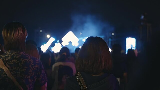 The crowd in a concert. Shot of some cheering fans enjoy in a free night live concert in music festival.