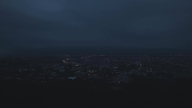 Time-lapse of the mist drifted over the city in the evening before it fade away. Fog over the city, city in fog. Zoom In.