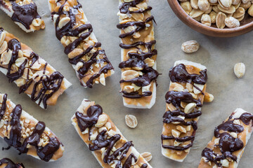 Frozen banana pieces topped with peanut butter and drizzled dark chocolate.