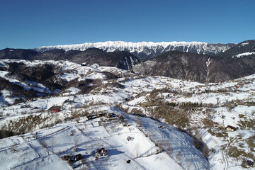 Beautiful winter snowy landscape with Piatra Craiului mountains and village, Carpathians, Romania