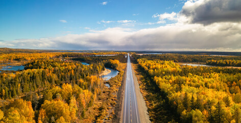 Highway Road by vibrant fall season color trees. Sunny Sky Aerial View. Newfoundland, Canada