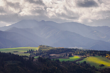 Mountain landscape. The sun's rays illuminate the valley. In the distance you can see the Low Tatras Zilina Region. Beszeniowa. Slovakia.