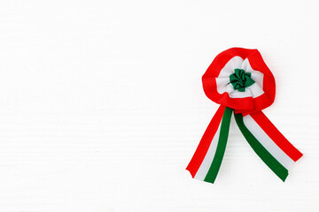 Cockade isolated on white wooden background.Tricolor rosette symbol of the hungarian national day...