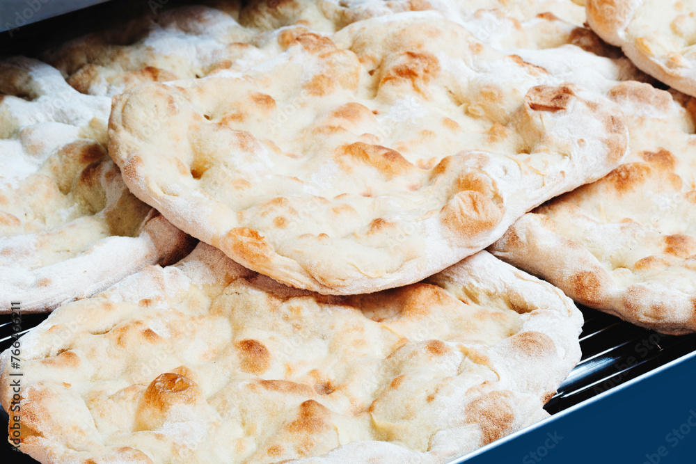 Poster fresh fragrant flatbread bread on a metal table in a bakery. nutrition concept